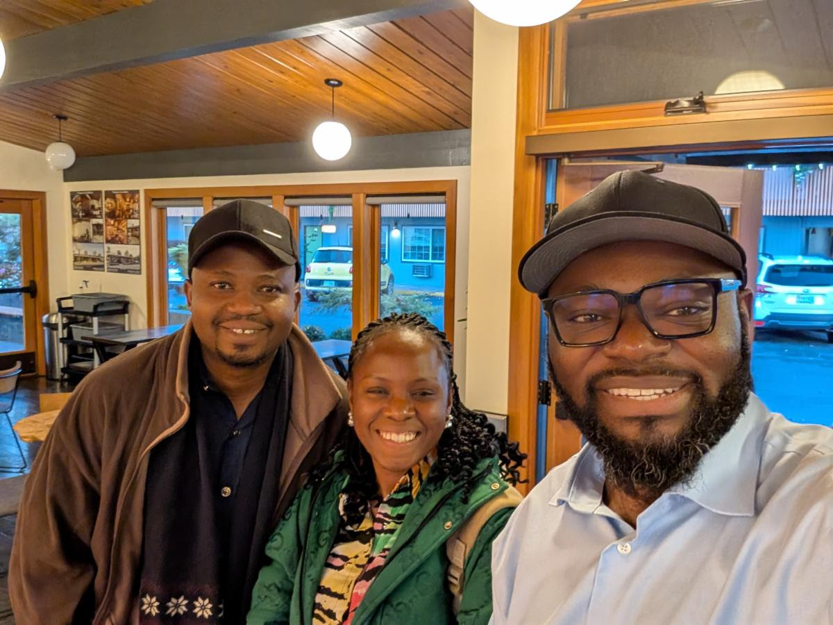 Bernard Ngalim, ELAW Africa Law Associate (right) collects Courage and Victory at the Eugene Airport Monday night.